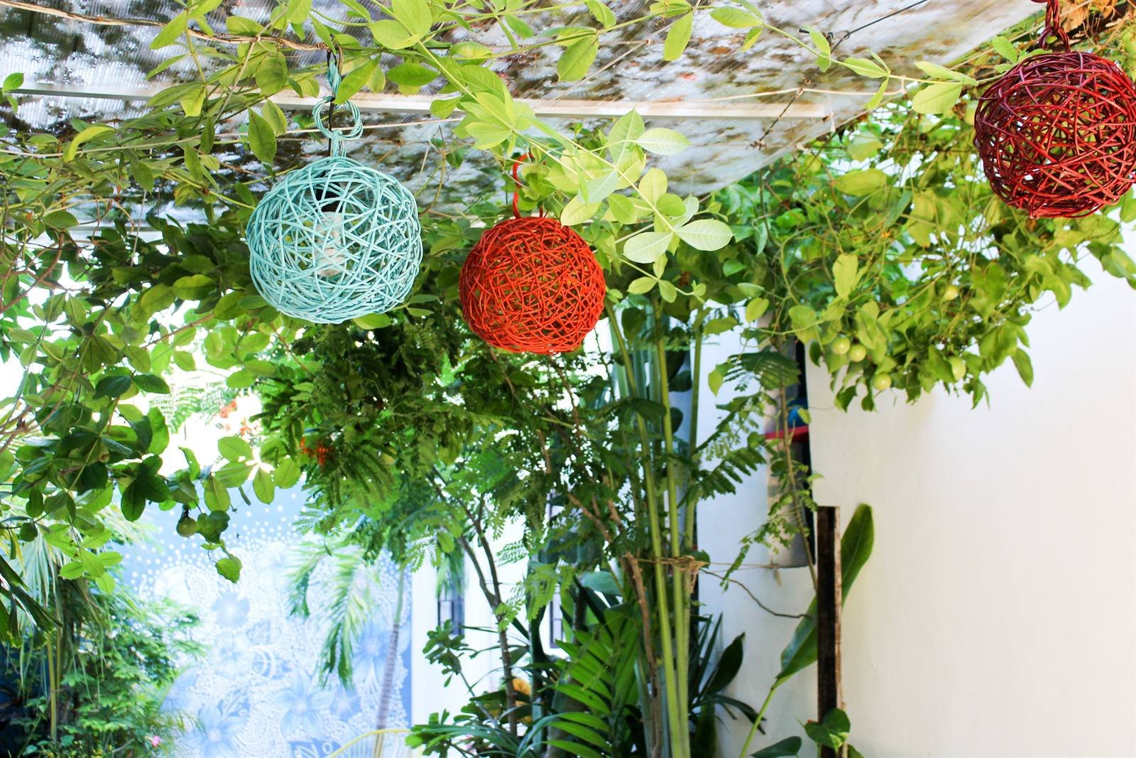 Common area with hanging lanterns, greenery and a patterned ceiling